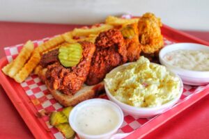 Hot chicken sandwich platter with fries and cole slaw, typical Nashville plate