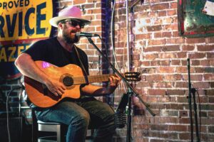 Local Nashville artist playing guitar at songwriter cafe